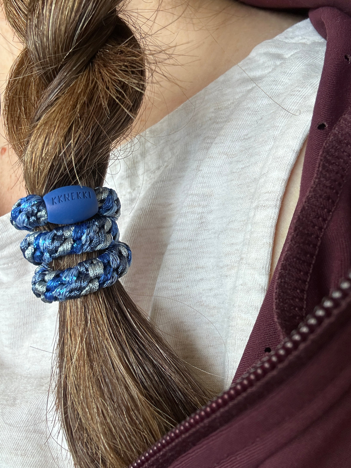 KKNEKKI Mix Blue Tones hair tie on close up of braided hair, branded bead visible
