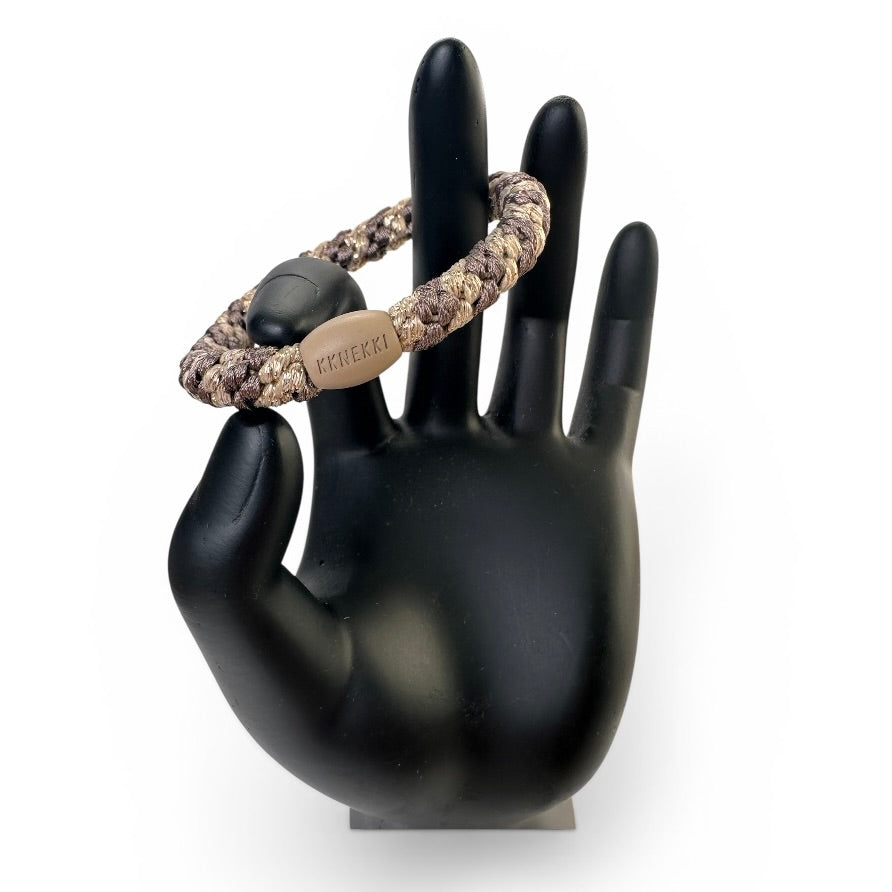 KKNEKKI Mole-Beige Glitter hair elastic on black model hand in front of white background, branded bead visible