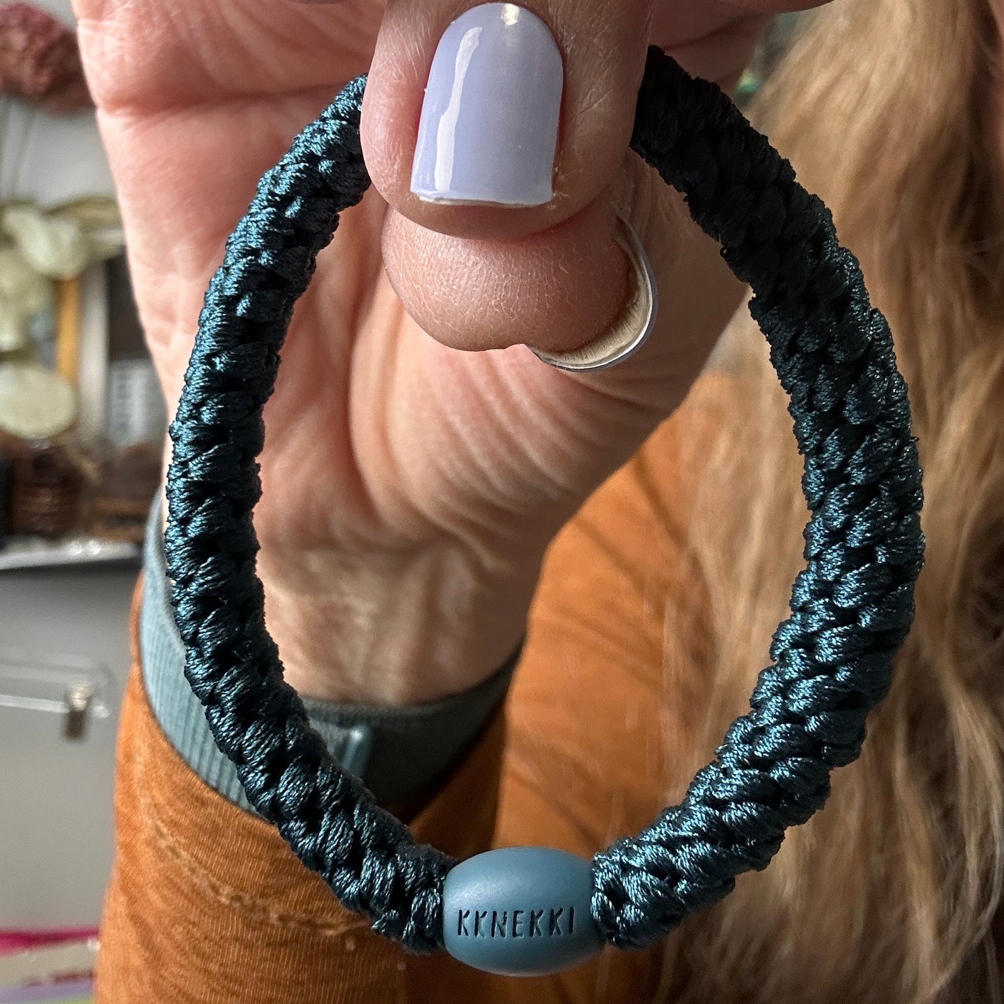 KKNEKKI Petrol hair elastic being held by a human hand