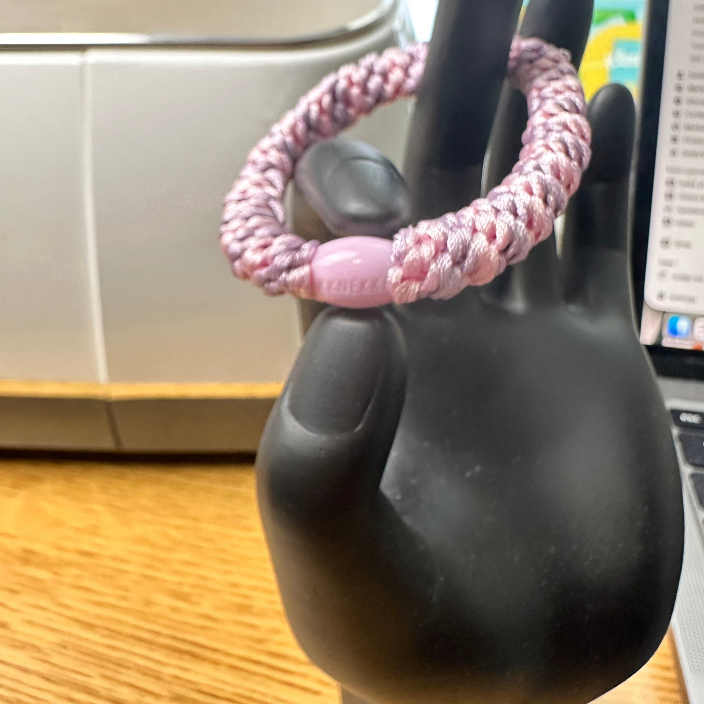 KKNEKKI Pink & Very Light Purple hair tie on black hand model with branded bead closeup