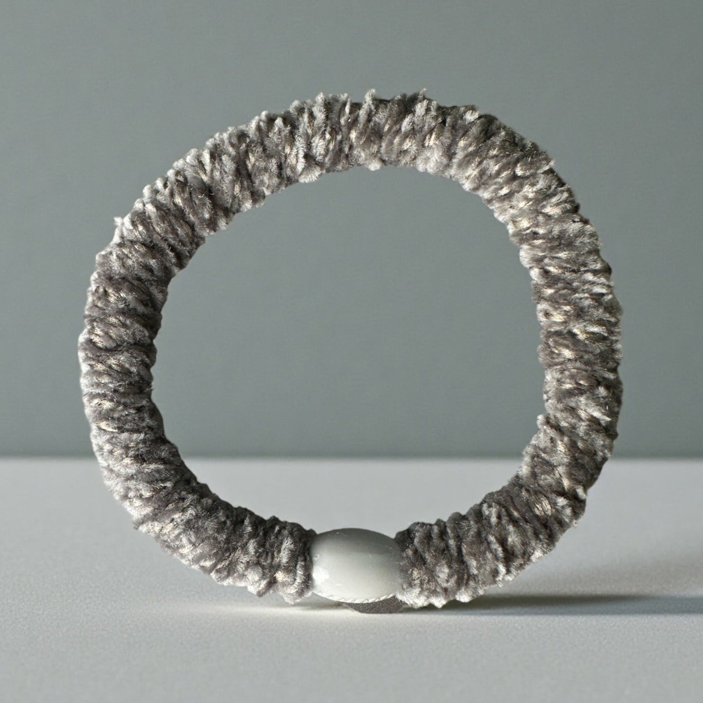 Grey Velvet KKNEKKI hair elastic/tie on grey background