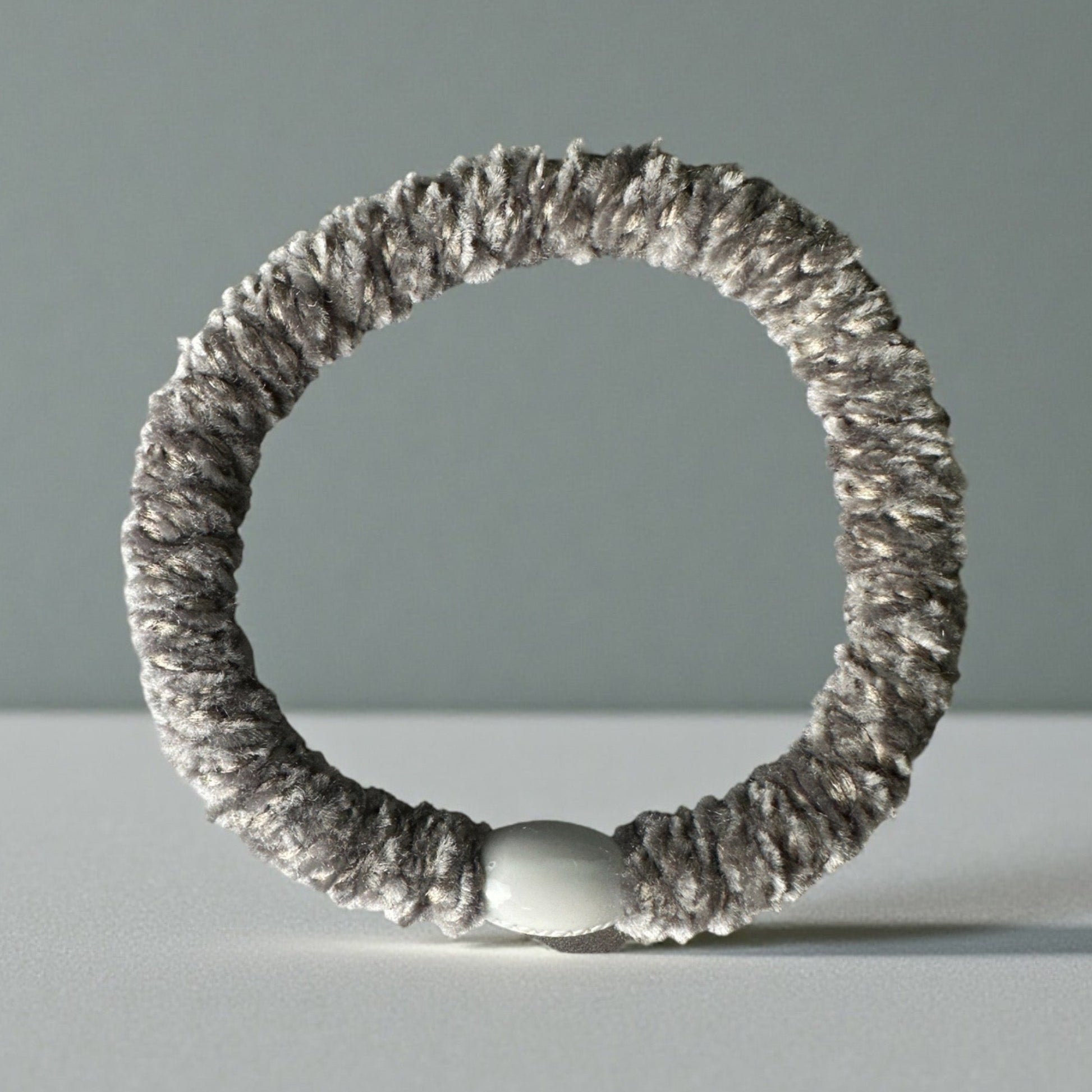Grey Velvet KKNEKKI hair elastic/tie on grey background