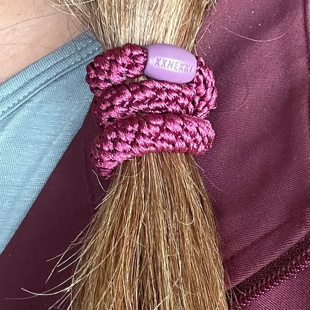 KKNEKKI Burgandy hair elastic worn in woman's medium dark hair, branded bead showing