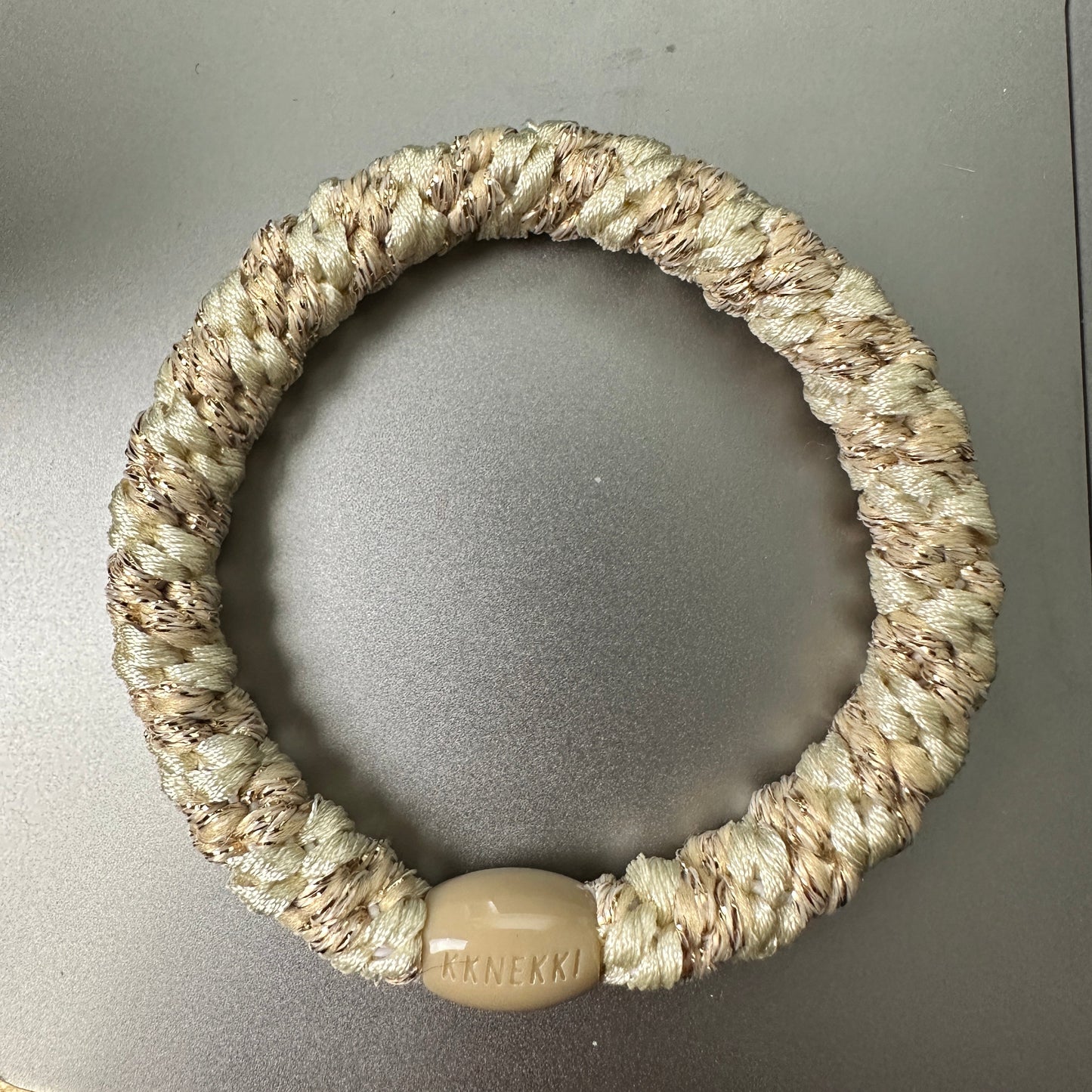 KKNEKKI Cream & Metallic Gold hair tie on grey background