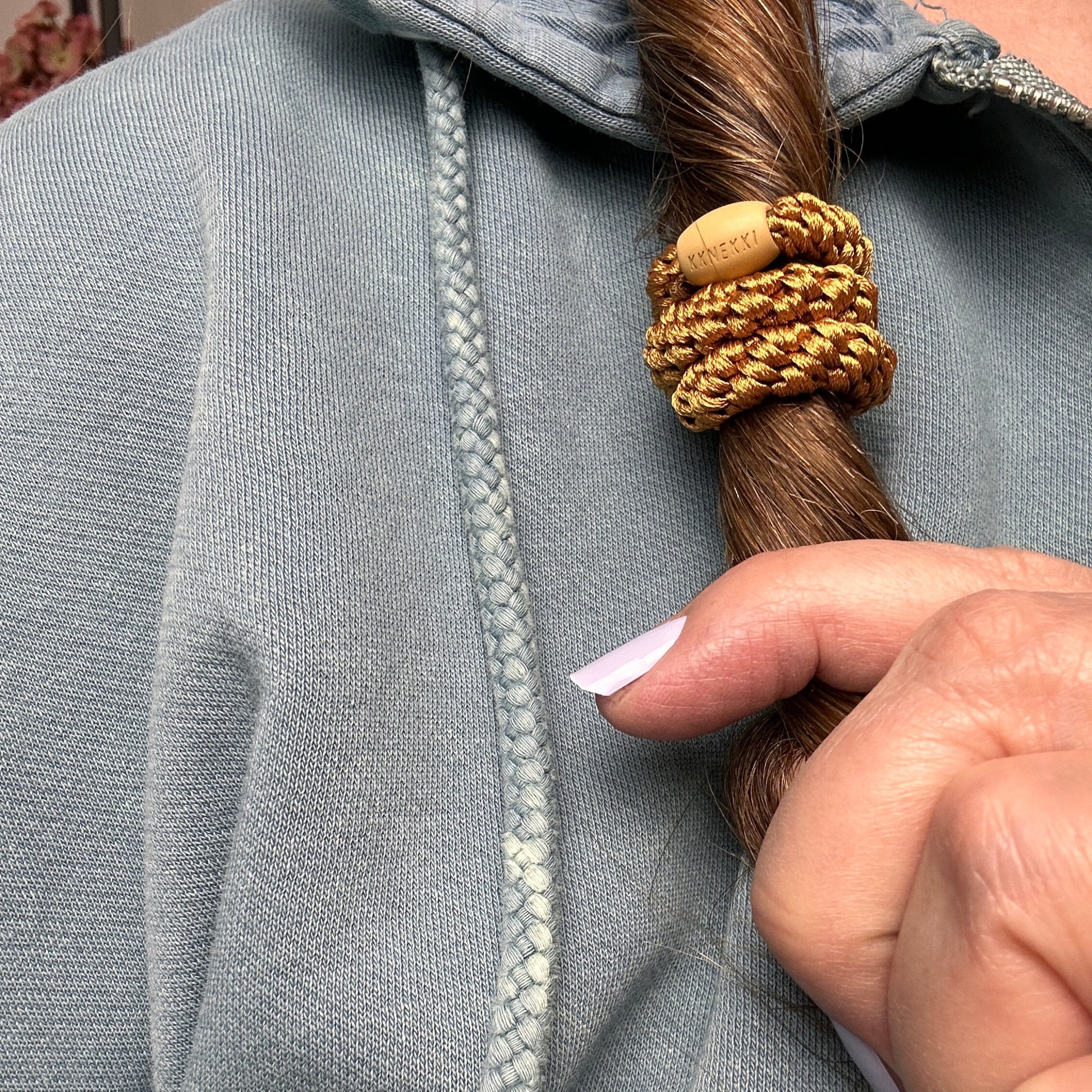 KKNEKKI Curry hair elastic in hair of person
