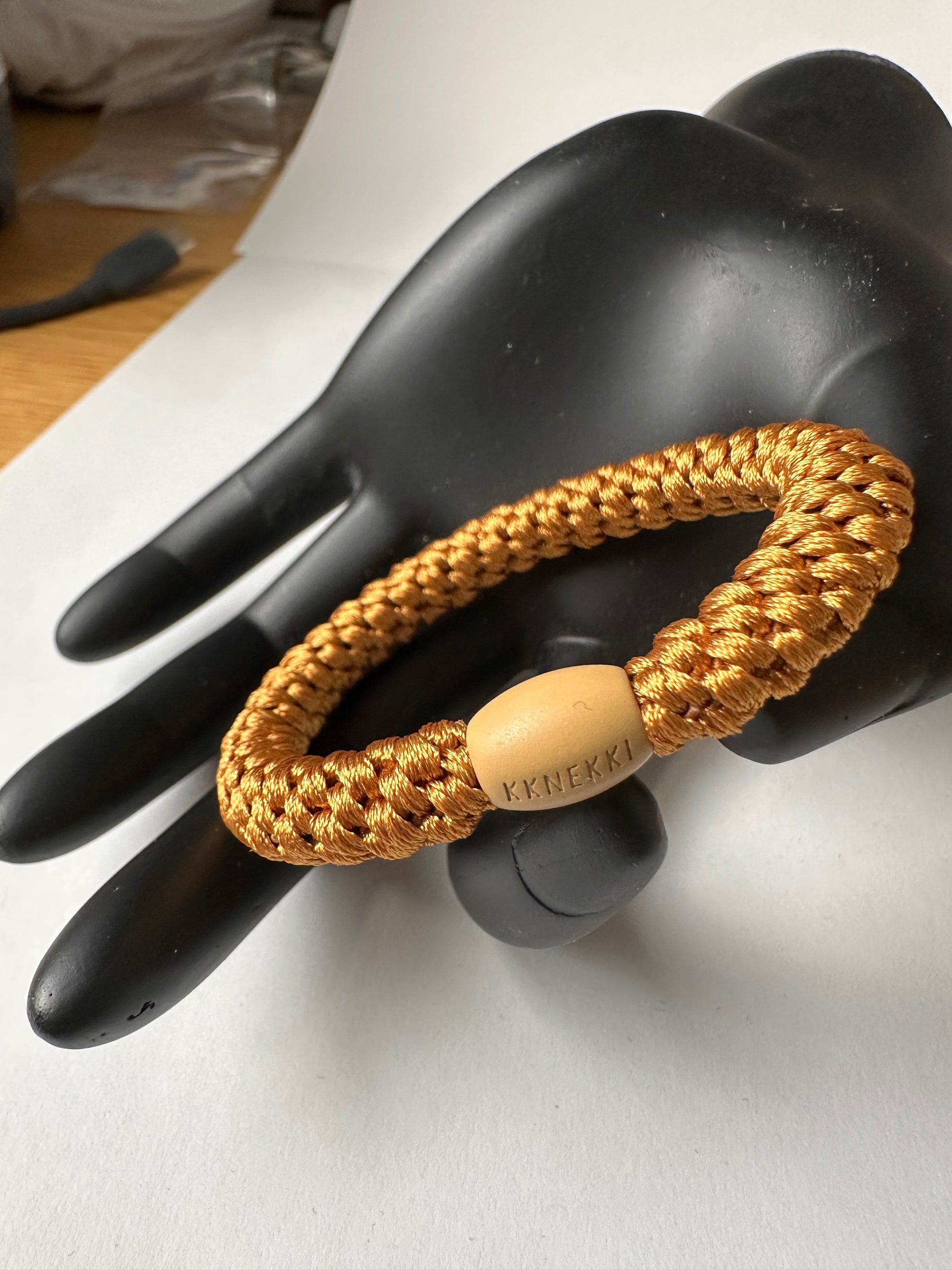 KKNEKKI Hair tie seen on black model hand