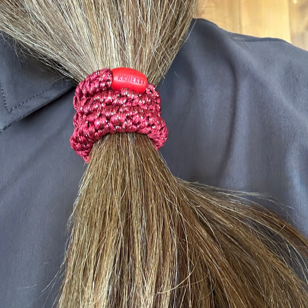 KKNEKKI Holiday Red hair elastic in brown-hair side ponytail with branded bead visible