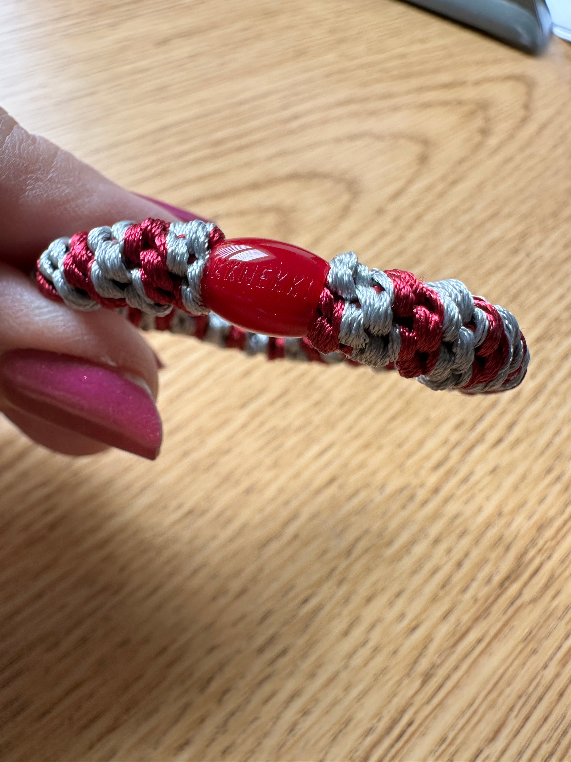 KKNEKKI Maroon-Grey hair elastics held between two fingers