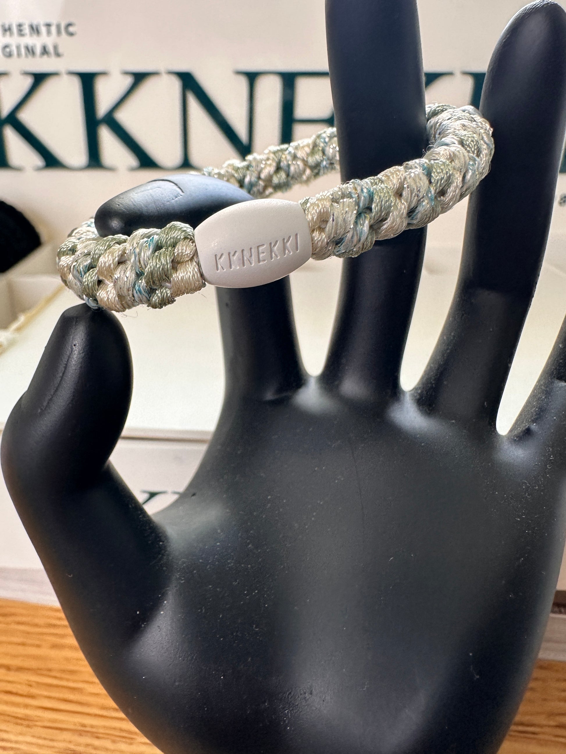 KKNEKKI Mix Ivory Glitter Dusty Lind Green hair elastic on black model hand