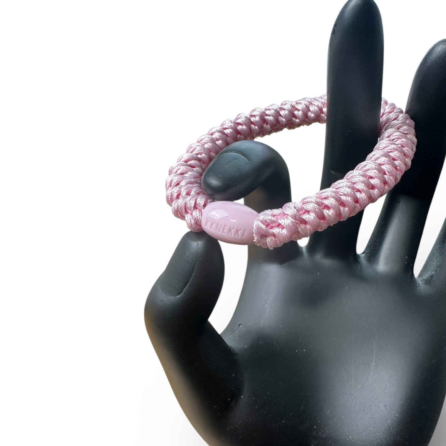 KKNEKKI Pink Light hair elastic on black hand model